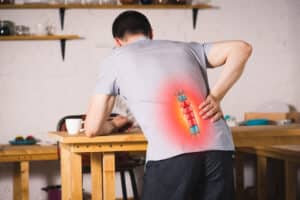 Pain in the spine a man with backache at home