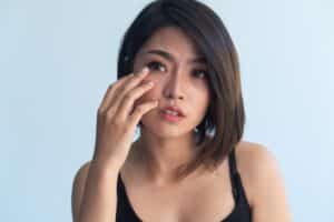 Woman touching her eye from hemifacial spasms in Dallas, TX